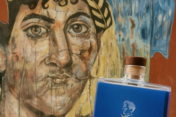 Bottiglia di Tesla Gin davanti a un murale artistico, con la scritta “Non è così antico”, a richiamare le antiche origini del gin.